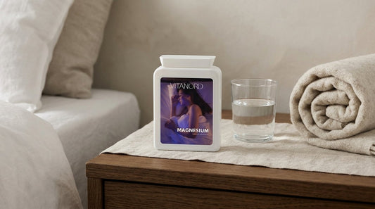 VitaNord Magnesium-burk på ett tränattygsbord bredvid ett glas vatten och en filt.
